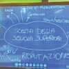 Una delle slide proiettate durante l'incontro, con la lavagna scritta dai ragazzi di terza media insieme agli psicologi